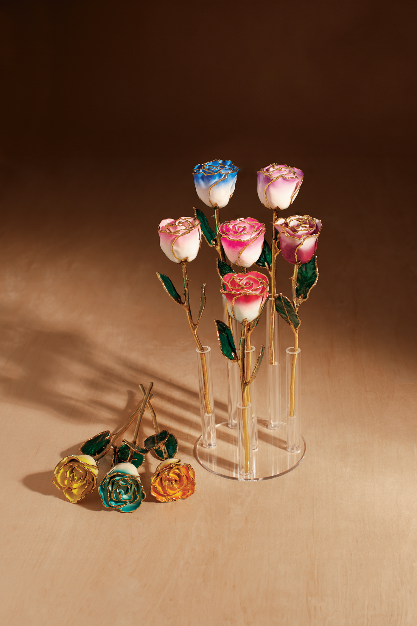 A selection of Everlasting Roses, showcasing an acrylic display stand holding 6 flowers hand painted with 24K gold trim.