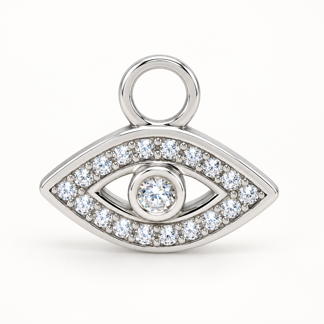 A silver-toned eye pendant charm paved with clear round and square crystals, featuring a central round crystal and a top loop, shown on a clean white background.