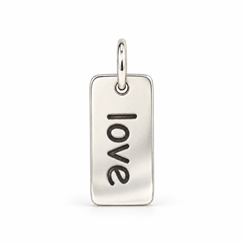 Rectangular sterling silver tag charm with rounded corners, engraved with “love” in lowercase letters, with a silver jump ring.
