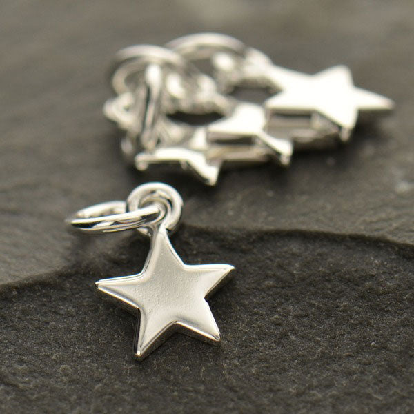Four sterling silver five-point star charms with attached jump rings.