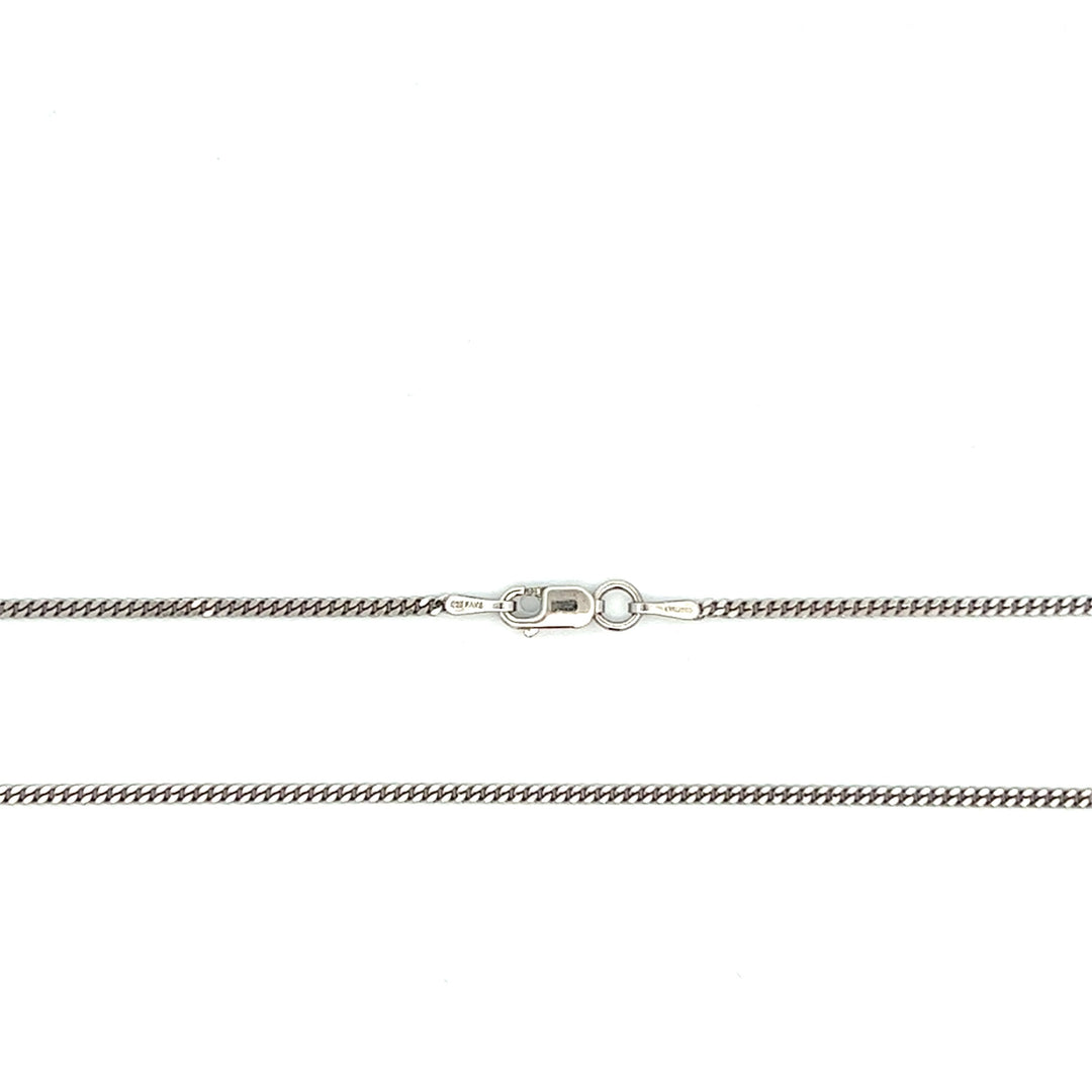 Close-up of fine 1.5 mm sterling silver curb chain with antiqued rhodium plating and a lobster clasp.