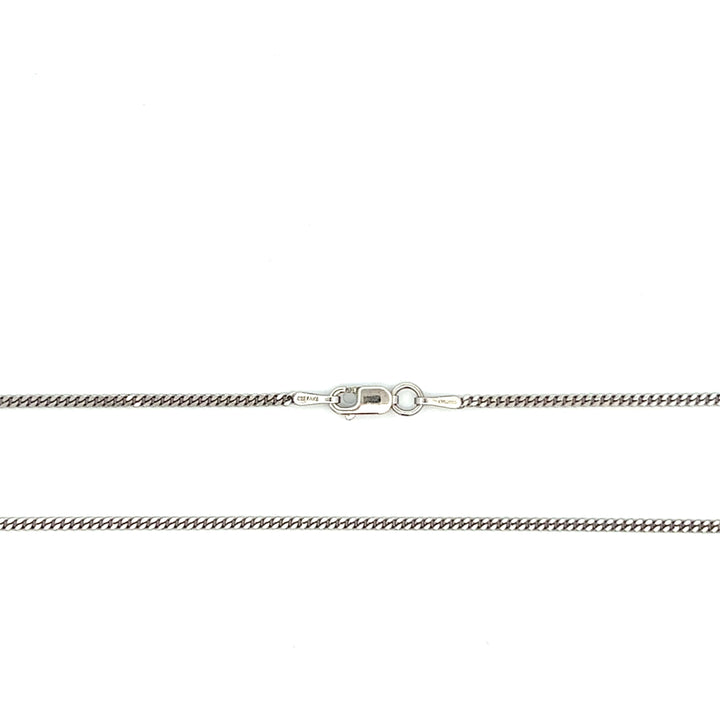 Close-up of fine 1.5 mm sterling silver curb chain with antiqued rhodium plating and a lobster clasp.