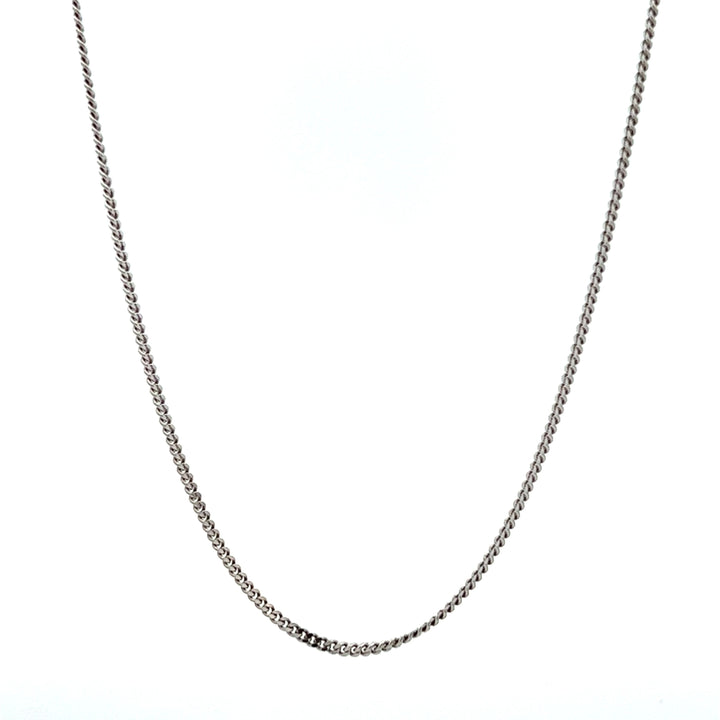 A rhodium plated sterling silver curb chain necklace laid out on a plain background.